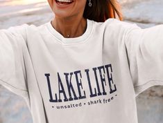 Super soft and comfy fleece sweatshirt will keep you warm and cozy and quickly become your favorite. Lake Life Unsalted Shark Free Crewneck Sweatshirt, Unisex Lake House Pullover Gift Design has been distressed for a vintage look. The sweatshirts in the pictures are solid color medium-heavy fabric with soft fleece inner lining. They are not pigment-dyed or vintage. * 50% cotton, 50% polyester * Medium-heavy fabric (8.0 oz/yd² (271.25 g/m * Double-lined hood * Double-needle stitching throughout * Air-jet spun yarn with a soft feel and reduced pilling * 1x1 athletic rib knit cuffs and waistband with spandex * Front pouch pocket PROPER SIZING Please see photos to see a specific sizing chart for this sweatshirt style. These shirts are unisex size, meaning they are not women's fitted shirts. If Florida Shirt, California Sweatshirt, Hampton Beach, Beach Sweatshirt, Breckenridge Colorado, Fitted Shirts, Memphis Tennessee, Vintage California, Cabo San Lucas