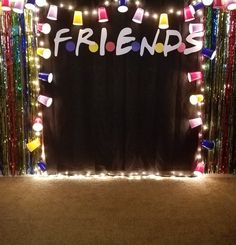 a black backdrop with the word friends on it and streamers all around it that says friends