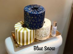 three rolls of toilet paper are stacked on top of each other in a bathroom with the words blue snow above them