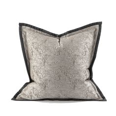 a silver and black pillow on a white background