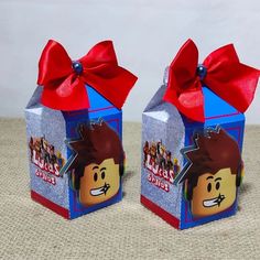 two lego movie themed boxes with red bows on the top and bottom, one is blue