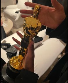 a person holding an oscar statue in their hand