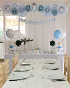 a table set up for a party with balloons, plates and napkins on it