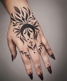 a woman's hand with black ink on it and an intricate design in the middle