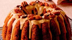 a bundt cake with icing and nuts on top