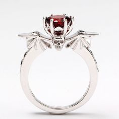 This dark and beautiful engagement ring is made with a gorgeous 1ct blood red natural garnet. Is accented by natural black sapphire and features a stunning skull with bat wings. Can be made in your choice of 925 sterling silver or 14k white gold. Can be made in yellow or rose gold upon request. Goth Wedding Ring, Goth Engagement Rings, Skull Vampire, Fantasy Punk, Vampire Ring, October Jewelry, Vampire Horror, Vampire Wedding, Gothic Wedding Rings