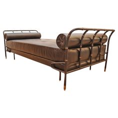 a brown leather daybed with metal frame and wheels on the back, sitting against a white background