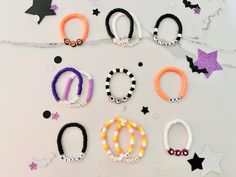 six different bracelets are arranged on a white surface with stars and confetti