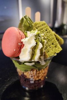 an ice cream sundae with green and white toppings in a glass dish on a table