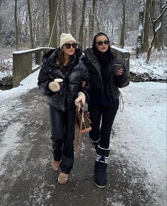 two women walking down a path in the snow