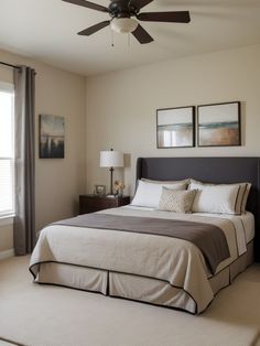 a bedroom with a bed, ceiling fan and two pictures on the wall above it