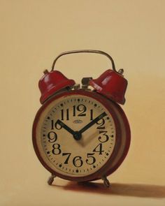 an old fashioned red alarm clock with two bells on the front and sides, against a beige background