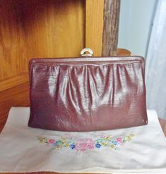 "This is a lovely chocolate brown \"Mardane\" handbag from the 50's or 60's. It's converts from a clutch to a shoulder bag in a flash, with a tuck-in gold chain. It's a subtle soft crackled leather purse with a leather covered frame and beige fabric lining. It has a gold half moon clasp and a unique flip-up mirror attached to the inside frame. It's a mirror on one side and the word \"Mardane\" is etched into metal on the other. It's still in great condition. It has a few minor specks inside. \"M Vintage Brown Satchel Clutch, Retro Brown Rectangular Clutch, Vintage Satchel Clutch For Everyday Use, Retro Clutch Bag For Vintage Events, Retro Clutch For Vintage Events, Vintage Brown Clutch Bag, Retro Brown Vintage Bags, Mid-century Brown Satchel Bag, Vintage Brown Shoulder Bag For Formal Occasions