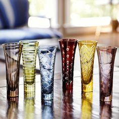 five different colored glasses sitting on top of a table