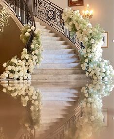 a staircase with flowers on it and chandelier in the background