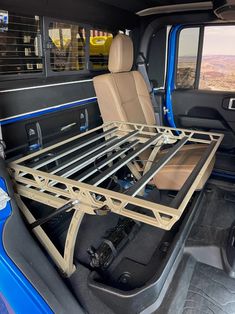 the back end of a blue truck with a bed in it