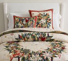 a white bed topped with lots of pillows