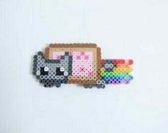 two pieces of beaded art on a white surface, one with a cat and the other with a rainbow