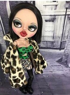 a creepy looking doll with big eyes and leopard print coat on it's head