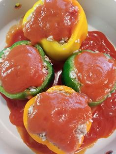 three peppers stuffed with meat and sauce in a white bowl