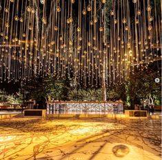 a large chandelier hanging from the ceiling in front of a building at night