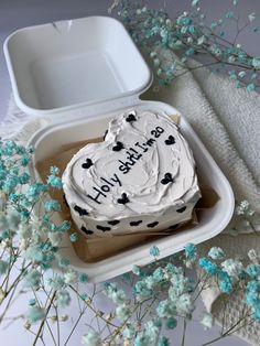 a heart shaped cake sitting on top of a white tray next to flowers and a napkin