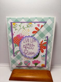 a card with the words live life and smile on it, sitting on a wooden stand