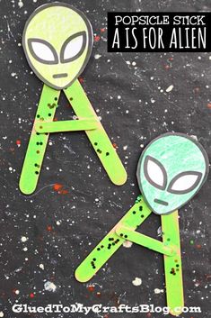 two alien popsicle sticks are sitting on top of each other with the words, popsicle stick as for alien