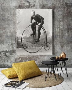 a vintage photo of a man riding an old fashioned bicycle in black and white with yellow accents