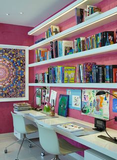 a room with two desks and bookshelves full of books on the wall