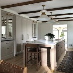 a large kitchen with an island in the middle and two stools next to it