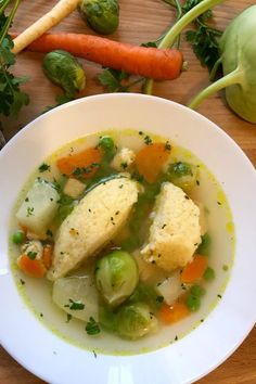 a white bowl filled with soup next to vegetables