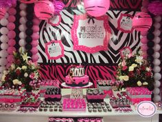 a pink and black zebra print birthday party with balloons, cake, cupcakes and decorations