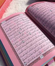 an open pink book with arabic writing on it