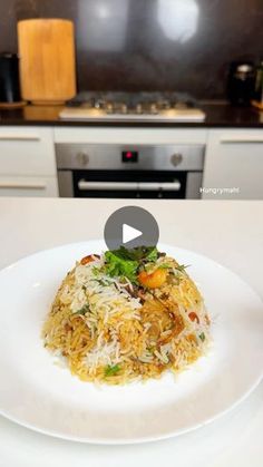 a white plate topped with rice covered in sauce and vegetables next to a stove top