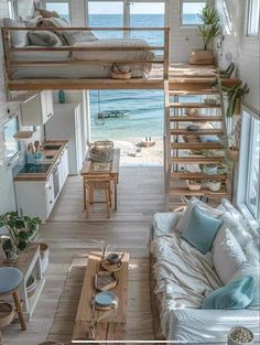 a living room filled with lots of furniture next to an ocean side house on the beach