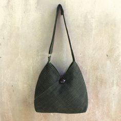 Vinita's flair for style and Thai elegance is evident in the modern design of this leaf green hobo bag. A removable coin purse adds to its versatile allure. Two exterior pockets are camouflaged among the diagonal pintucks that shape the cotton shoulder bag. The fully-lined interior includes two open pockets as well as a zipper pocket. The shoulder strap's length is adjustable and an ornate rain tree wood button closes the bag. Green Hobo Bag With Adjustable Strap For On-the-go, Green Hobo Shoulder Bag For Daily Use, Green Crossbody Hobo Bag For Daily Use, Everyday Handheld Hobo Bag With Single Handle, Everyday Use Handheld Hobo Bag With Single Handle, Everyday Use Handheld Hobo Bag, Green Hobo Bag With Detachable Strap For Travel, Dark Green Bag With Adjustable Strap For Daily Use, Dark Green Satchel Shoulder Bag For Daily Use