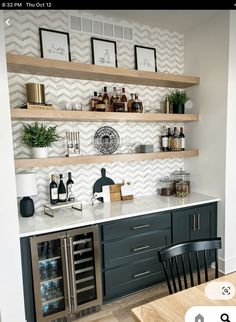 a kitchen with open shelving above the sink and wine bottles on the counter top