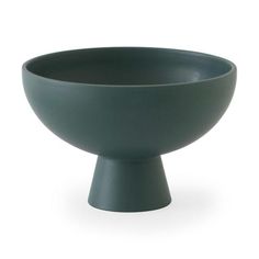 a green bowl sitting on top of a white table