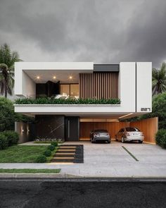 two cars parked in front of a modern house