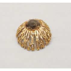 This is part of Chairish’s Costume Jewelry assortment.  1970s modernist round domed goldtone with unfoiled open backed faux-topaz center brooch with security clasp. Marked "Napier" with a copyright symbol. Measures: 1 7/8 inches across. Condition: Very good; some light wear/silvering to high points which isn't very noticeable. Gold Modernist Brooch For Formal Occasions, Modernist Gold Brooch For Formal Occasions, Modernist Gold Brooch Jewelry, Modernist Gold Brooch, Gold Oval Brooch For Evening, Unique Gold Brooch With Cabochon, Unique Gold Brooches With Cabochon, Copyright Symbol, Vintage 1970s