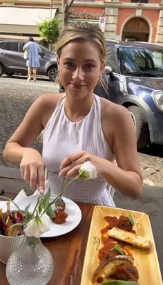 a woman sitting at a table with food in front of her