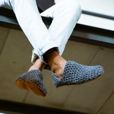 a person sitting on top of a bench wearing slippers