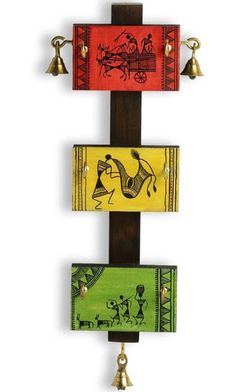 three pieces of art hanging from a cross with bells on each side and an image of horses