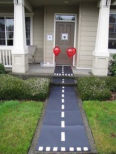 a house with a painted walkway leading to the front door and two red heart balloons