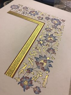 a piece of paper that has been cut out with gold and blue flowers on it