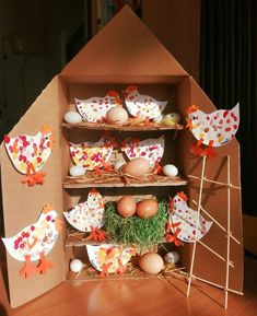 an open cardboard box filled with eggs and other decorations on top of a wooden table