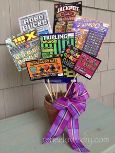 a wooden table topped with a potted plant filled with cards and stickers next to a wall