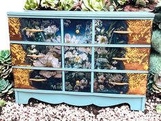 an old dresser painted with flowers and succulents