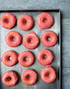 nine glazed donuts on a baking sheet ready to be baked in the oven,